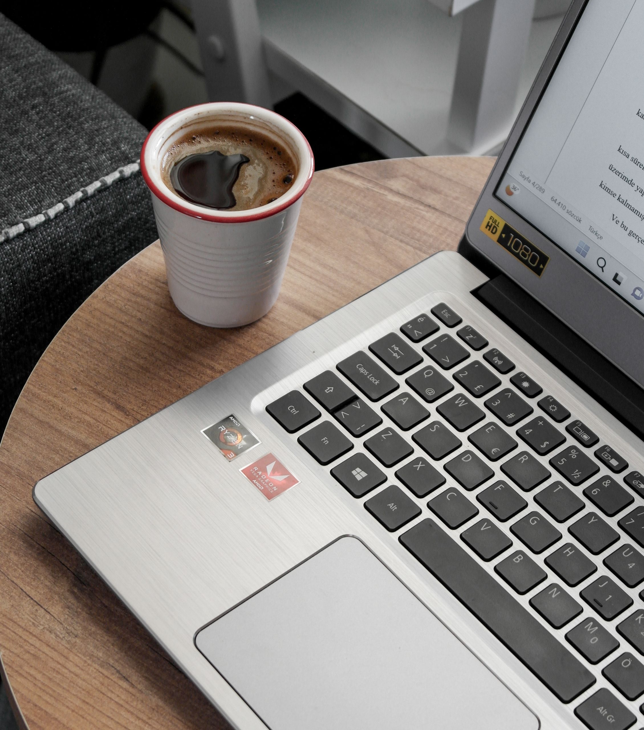 A close-up view of a laptop and coffee cup on a wooden table, ideal for workspace themes.